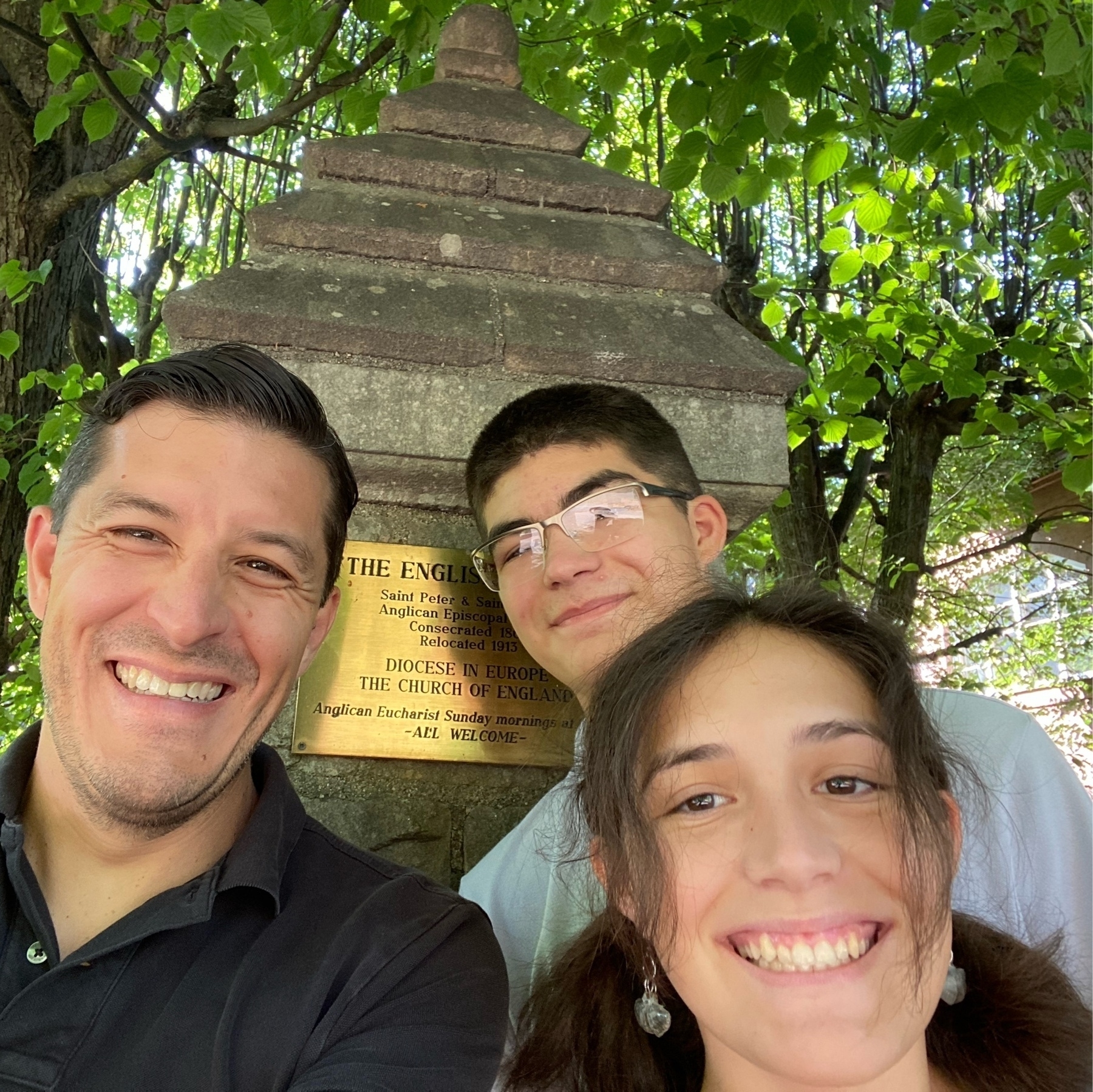 family selfie in front of church plaque