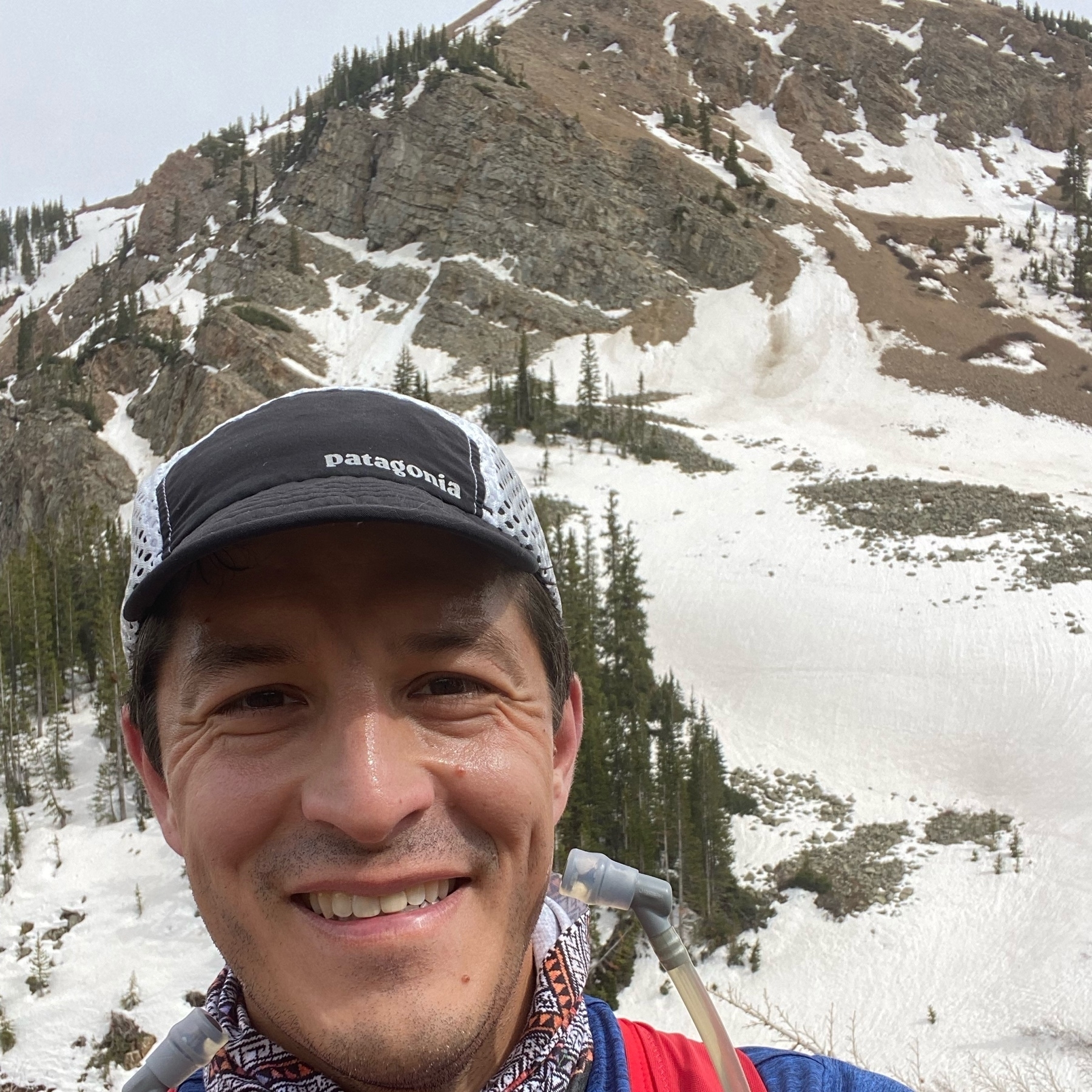 Trail selfie of Aaron with snow in background. 
