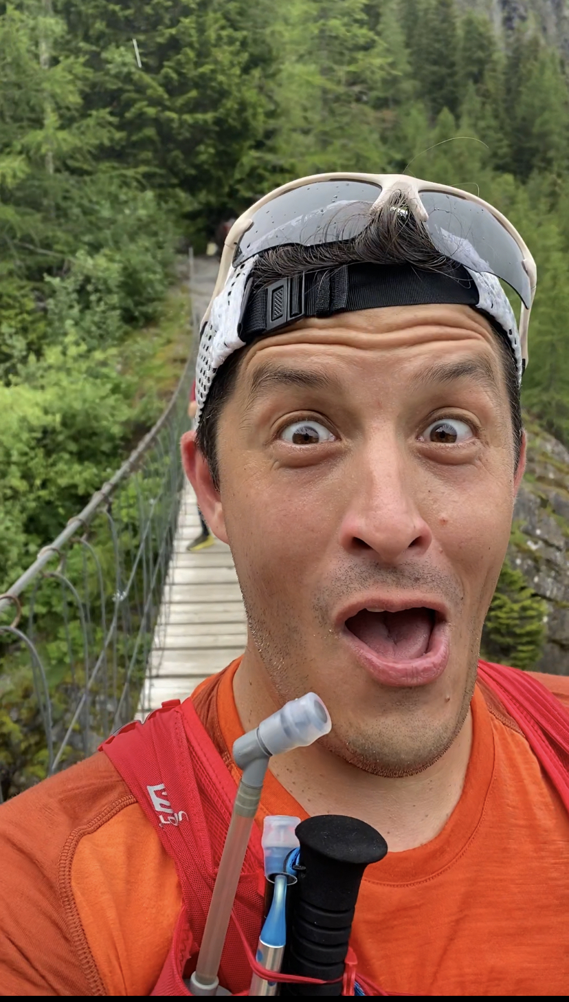 selfie of aaron on a suspension bridge over an alpine water fall