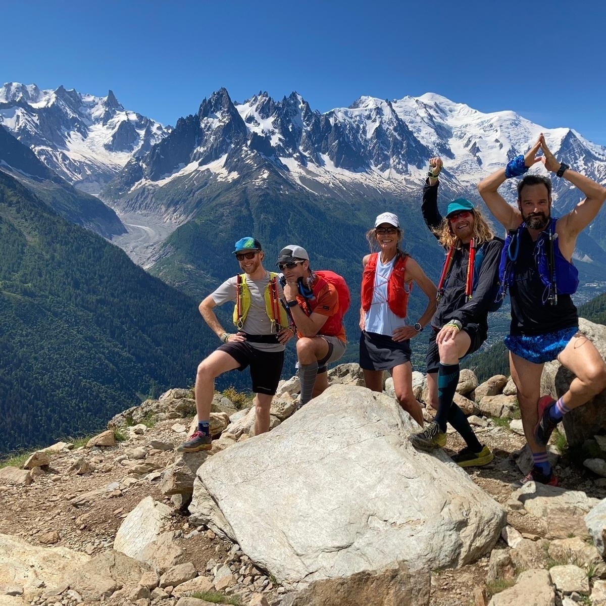 a group of runners with the alps behind them. 